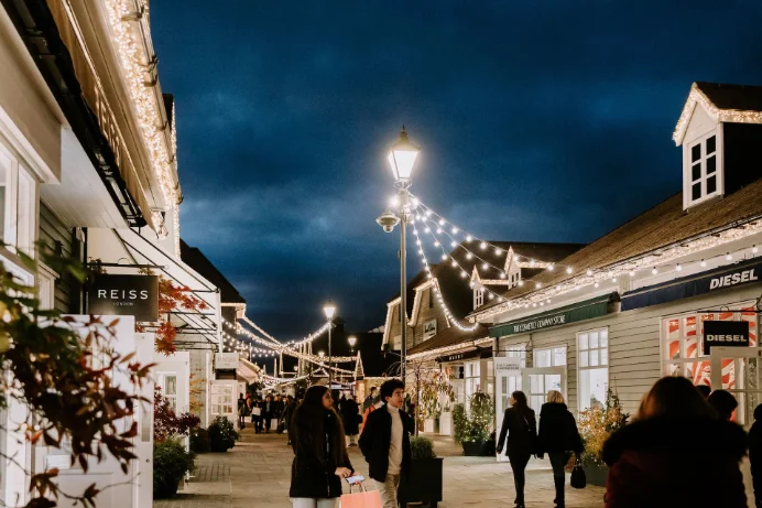 Bicester Village shopping street strung with Christmas lights in the evening